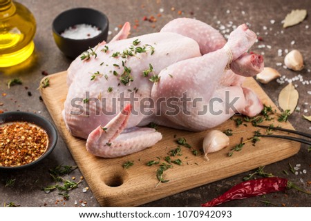 Fresh raw chicken on cutting board and spices for cooking