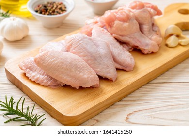 fresh raw chicken wings on wooden board with ingredients - Shutterstock ID 1641415150