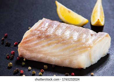 Fresh Raw Cod With Lemon On Black Stone Board 