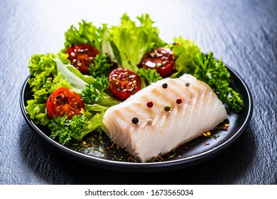 Fresh Raw Cod With Vegetables On Black Stone Board