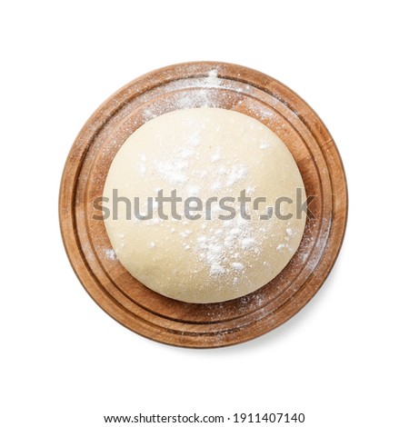 Fresh raw dough for pizza or bread baking on wooden cutting board isolated on white background. top view