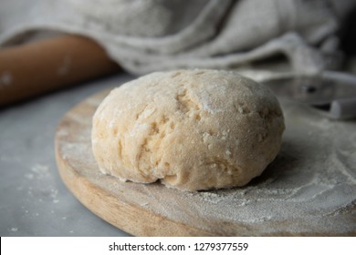 Fresh raw dough and rolling pin. Cooking pasta process. Food preparation.