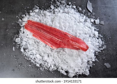 Fresh Raw Fish Steak On Ice Over Dark Stone Background. Creative Layout Made Of Fish