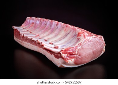 Fresh Raw French Whole Rack Of Pork Loin With Ribs On Black Board.