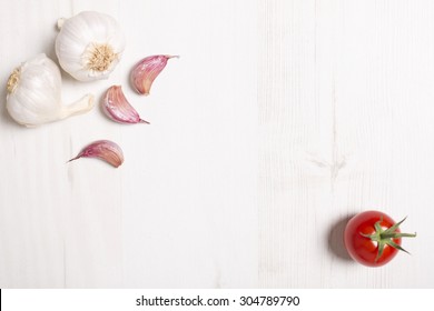 Fresh raw garlic on a light wooden kitchen work surface Stock Photo