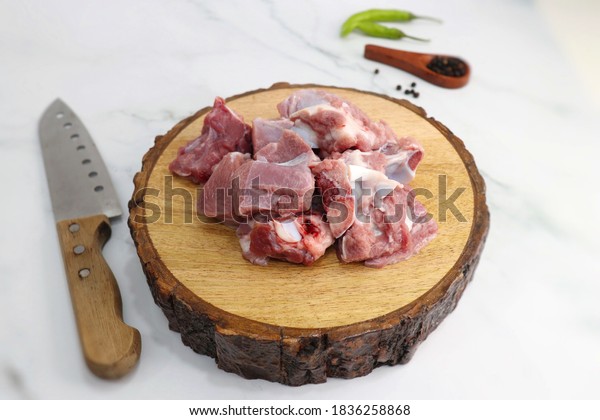 Fresh raw goat meat or mutton or lamb pieces.\
Preparation for Indian mutton curry. Spice at the background such\
as cinnamon sticks, red chili powder, black pepper &\
coriander. Copy space.