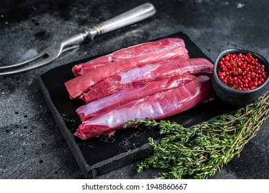 Fresh Raw lamb tenderloin Fillet, Mutton Sirloin Meat on marble board with thyme. Black background. Top view