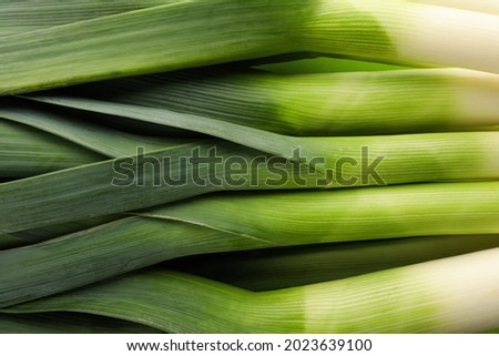 Fresh raw leeks as background, top view