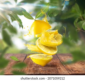 Fresh Raw Lemons Falling In The Air On Wooden Table Over Defocused Bokeh Background. Food Levitation Concept. Zero Gravity Fruit Conception. High Resolution Image