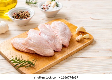 fresh raw middle chicken wings on wooden board with ingredients - Shutterstock ID 1666794619