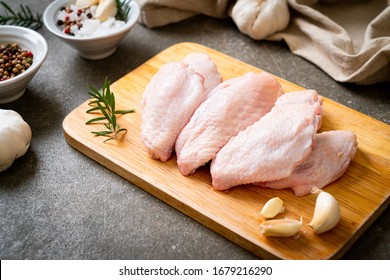 fresh raw middle chicken wings on wooden board with ingredients - Shutterstock ID 1679216290