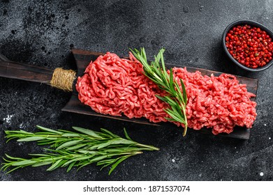 Fresh Raw mince beef, ground meat with herbs and spices. Black background. Top view