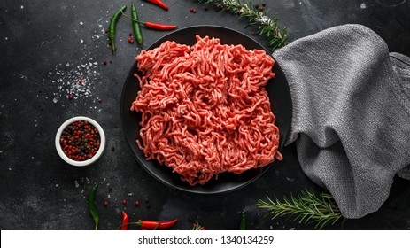 Fresh Raw mince, Minced beef, ground meat with herbs and spices on black plate