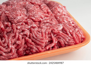 Fresh raw minced beef meat in an orange plastic tray. Packaging template mockup. 