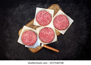 Fresh Raw Minced Homemade Grill Beef Steak Burgers. Raw BBQ Beef Burger Cutlets On Wooden Board, Overhead View. Raw Ground Beef Pork Meat Burger Cutlets For Grilling Or Frying. Raw Hamburger Patty.