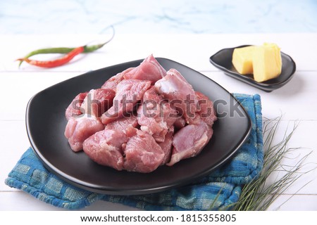 Fresh raw mutton boneless pieces on black plate