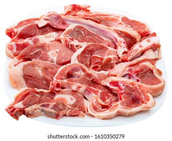 Fresh and raw mutton meat - leg steaks and rib chops on white plate. Isolated over white background