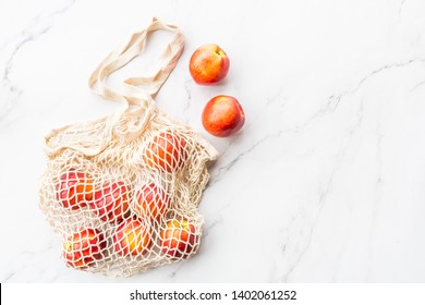 Fresh Raw Nectarines Lying In String Bag On White Marble Background. Flat Lay, Top View Summer, Organic Food, Blogger Style