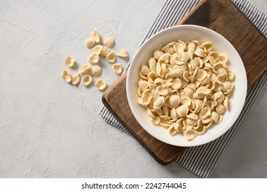 Fresh raw orecchiette pasta made from whole wheat flour on white background. Copy space. Top view. - Shutterstock ID 2242744045