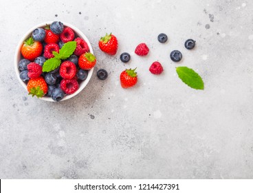 Fresh raw organic berries in white ceramic bowl on kitchen table background. Space for text. Strawberry, Raspberry, Blueberry and Mint leaf - Powered by Shutterstock