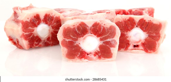 Fresh Raw Oxtails (ox Tails) Cut On White Cutting Board Over White.