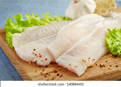fresh raw pangasius fish fillet on wooden cutting board