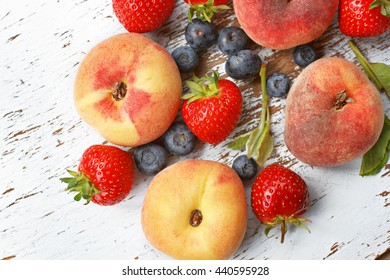 Fresh Raw Peaches, Strawberries And Blueberries On Table