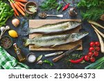 Fresh raw pike perche or zander and pike fish with ingredients prepared for cooking on rustic kitchen table
