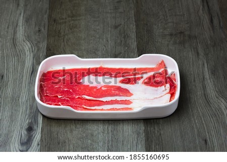 fresh raw pork, meat ,beef, belly, sliced on square plate  on wood, wooden background,set shabu, hot pot ingredients.