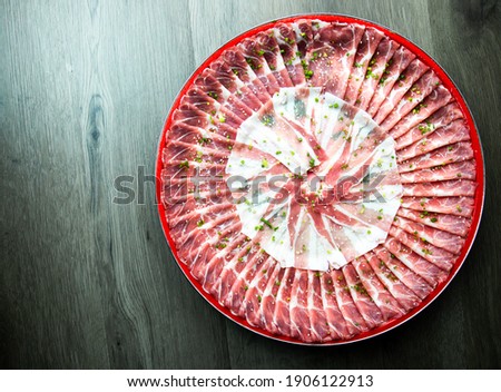 fresh raw pork, meat ,beef, belly, sliced on square dish disk plate  on fabric and wood, wooden background, shabu, hot pot ingredients.
