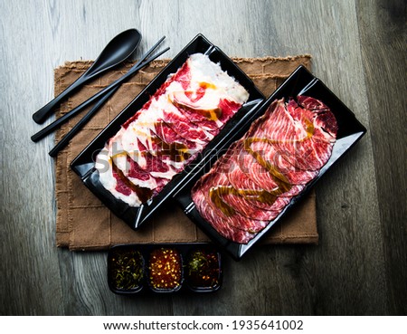 fresh raw pork, meat ,beef, belly, sliced on square plate  on fabric and wood, wooden background, shabu, hot pot ingredients.
