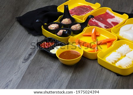 fresh raw pork, meat ,beef, belly,crab stick sliced on square plate  on wood, wooden background,set shabu, hot pot ingredients.