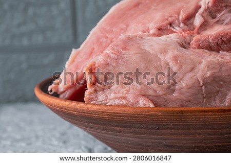 Fresh raw pork meat in rustic ceramic bowl ready for home cooking