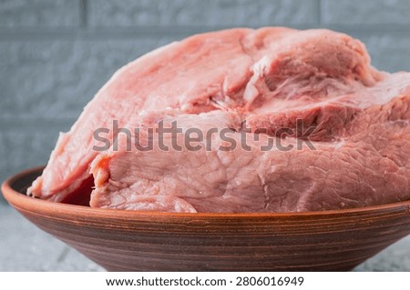 Fresh raw pork meat in rustic ceramic bowl ready for home cooking