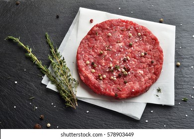 Fresh Raw Prime Black Angus Beef Burger Patty On Black Stone Background