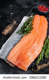 Fresh Raw Salmon Fillet Fish On Cutting Board With Knife. Black Background. Top View