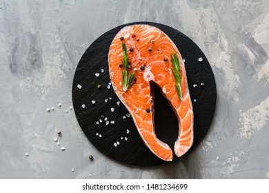 Fresh Raw Salmon Fish Steak With Spices On Dark Stone Background. Creative Layout Made Of Fish, Top View, Flat Lay, Mockup, Overhead. Healthy Food Concept