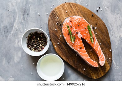 Fresh Raw Salmon Fish Steak With Spices On Dark Stone Background. Creative Layout Made Of Fish, Top View, Flat Lay, Mockup, Overhead. Healthy Food, World Food Day Concept