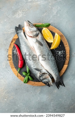 Fresh raw sea bass on light background. vertical image. top view. place for text.