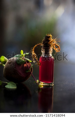 Fresh raw sliced beetroot along with some mint leaves and its extracted detoxifying essential oil in a tiny glass bottle.Vertical shot with blurred background.