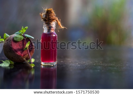 Fresh raw sliced beetroot along with some mint leaves and its extracted detoxifying essential oil in a tiny glass bottle.Horizontal shot with blurred background.