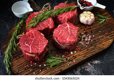 fresh raw steaks fillet Mignon prepared for cooking, close seasoning, salt, pepper and wooden background. rustic style
