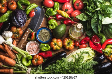 Fresh raw vegetable ingredients for healthy cooking or salad making, top view. Olive oil in bottle, spices and knife. Diet or vegetarian food concept