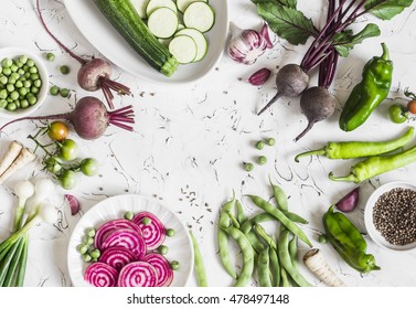 Fresh raw vegetables - beets, green peas and beans, zucchini, peppers, onions, garlic, spices on a light background. Cooking background, space for text. Top view 