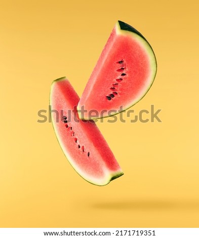 Fresh raw watermelon falling in the air isolated on yellow backgeound. Food levitation or zero gravity conception. igh resolution image.