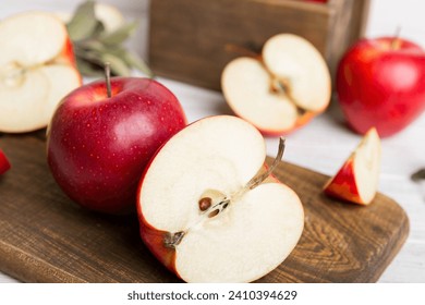 Fresh red apples with green leaves on table. cutting board with knife. Top view. - Powered by Shutterstock