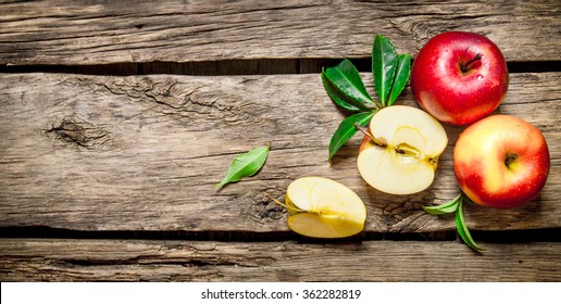 Fresh red apples with green leaves on wooden table. On wooden background. Free space for text . Top view - Powered by Shutterstock