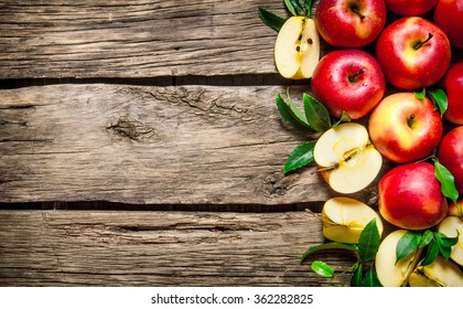 Fresh red apples with green leaves on wooden table. On wooden background. Free space for text . Top view - Powered by Shutterstock