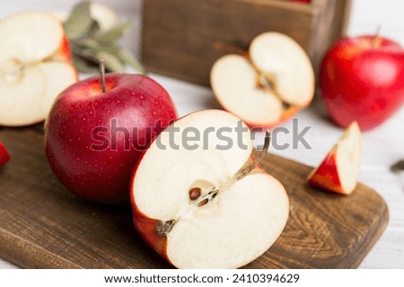 Fresh red apples with green leaves on table. cutting board with knife. Top view.