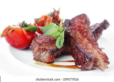 fresh red beef meat steak barbecue garnished vegetable salad and basil  in half of pepper bell on white plate isolated over white background